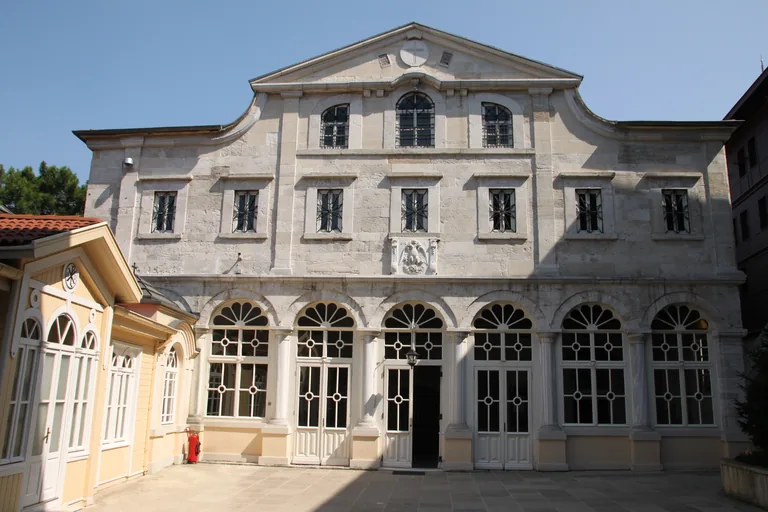 The pale stone front of the Church of St George, with arched glazed doors along the ground floor.