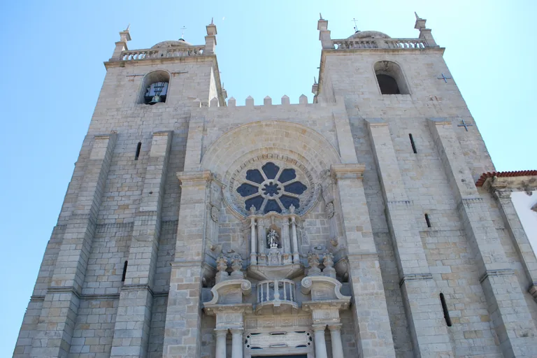 The twin towered granite front of Porto Cathedral with its rose window.