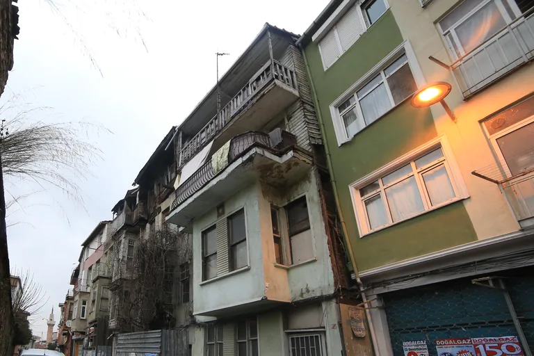 Narrow painted houses with bay windows and balconies along a street in Balat.