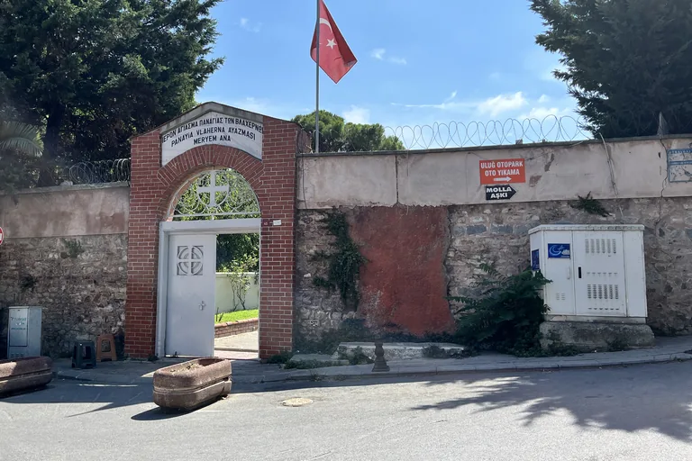 The brick gateway in the garden wall of the Church of St Mary of Blachernae, beneath a Turkish flag.
