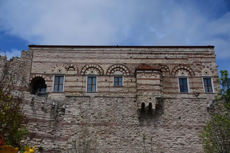 The restored front of Tekfur Palace, with bands of brick and stone and arched windows.