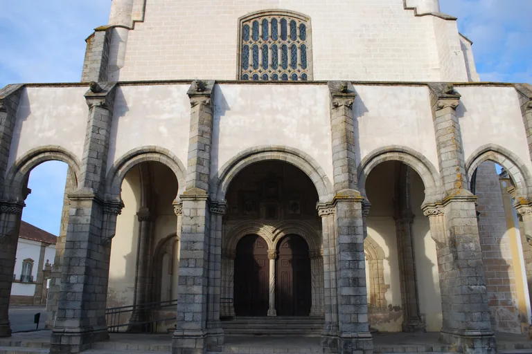 The arcaded granite porch of the Church of São Francisco, with arches on stout piers before the double main door.
