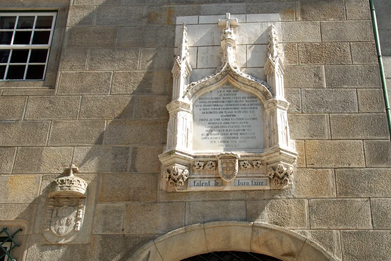 The carved commemorative plaque on the stone wall of the Casa do Infante.