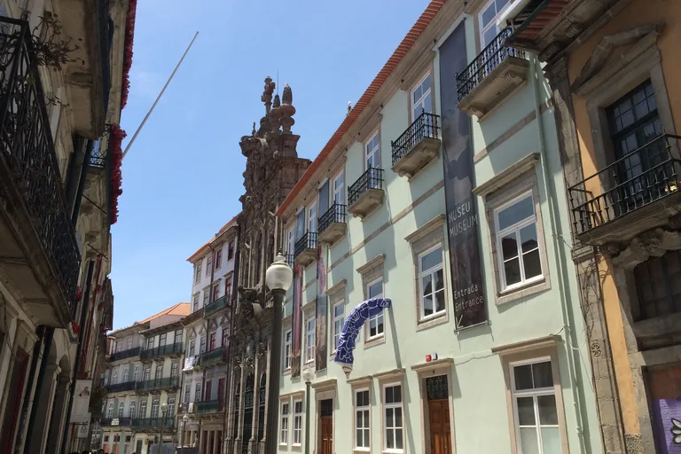 Rua das Flores with balconied house fronts and the carved Baroque front of the Misericórdia church.