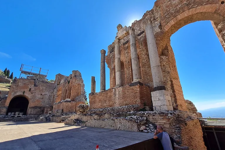 Standing brick arches and columns inside Taormina's ancient theatre.
