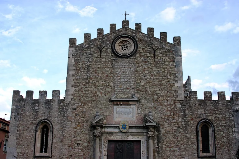 The crenellated stone facade of Taormina Cathedral.