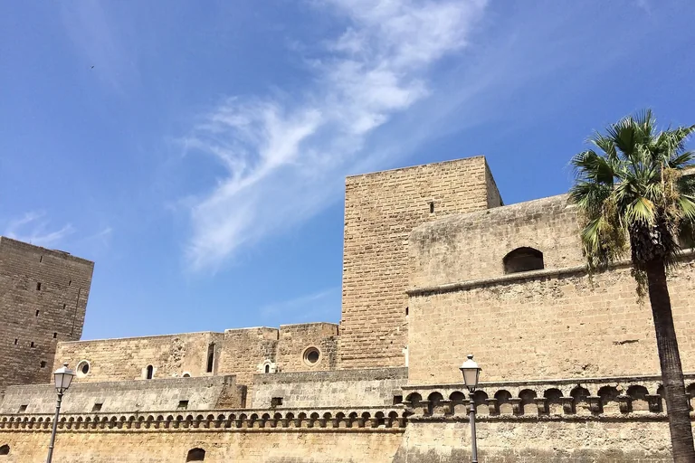 The pale-stone exterior and square tower of Bari's Norman-Swabian Castle.