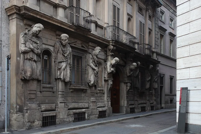 The sculpted stone figures across Casa degli Omenoni's street facade in Milan.