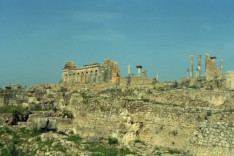 Stone city walls and basilica ruins at the southern edge of Volubilis.