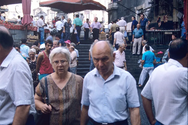 Crowded stalls and shoppers at Catania's fish market.