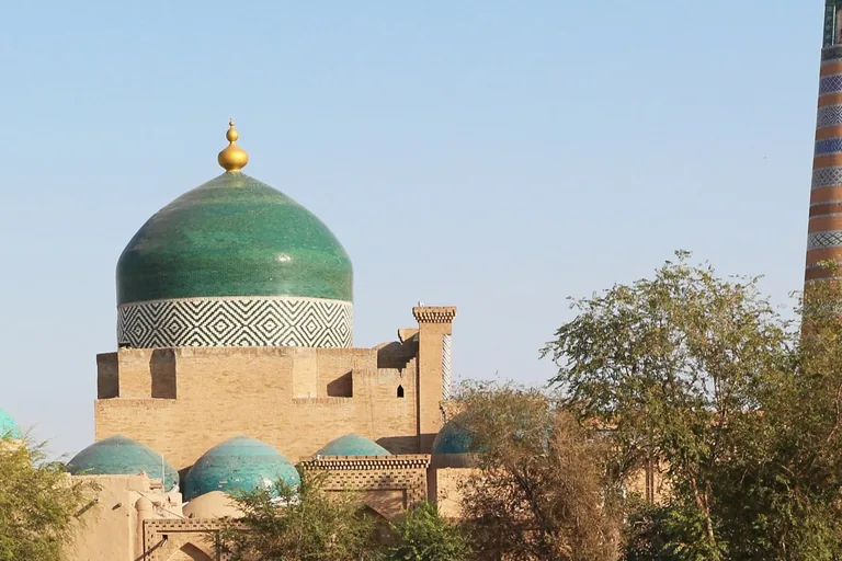 Pahlavon Mahmud's turquoise dome — the only Timurid-style blue dome in Khiva — with the Islam Khodja minaret behind
