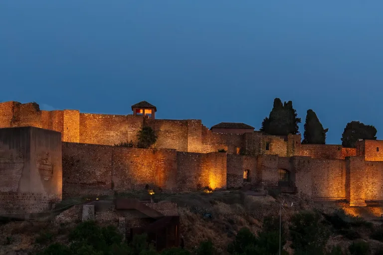 The layered walls of Málaga's Alcazaba seen across the hillside at dusk