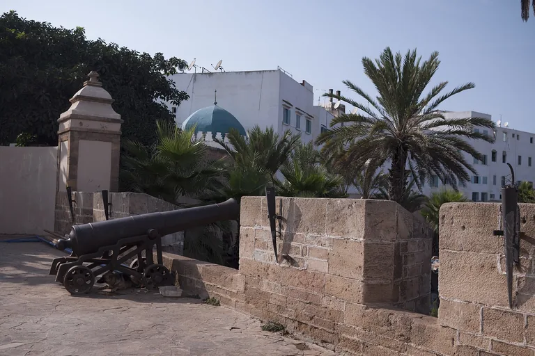 Historic cannon mounted on La Sqala's stone coastal bastion.