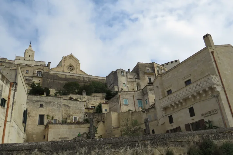 Stone façades and stacked lanes descending through Sasso Barisano.